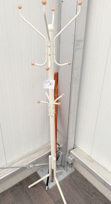 a white coat stand with a coat rack on top of it
