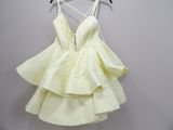 yellow dress hanging on a hanger against a white wall