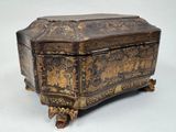 an old wooden box with gold decorations on it sitting on a white surface