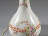 an image of a white vase with a gold base and a floral design on it