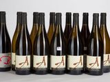 six bouteilles de vin sont alignées sur une surface blanche