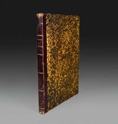 un vieux livre à la couverture brune posé sur une table