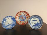 trois assiettes bleues et blanches posées sur une table en bois