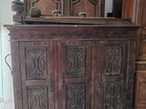 une grande armoire en bois ornée de sculptures sur le dessus