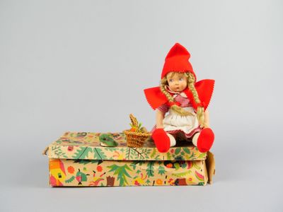 une poupée assise sur une boîte