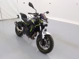 une photo d'une moto garée dans une pièce blanche