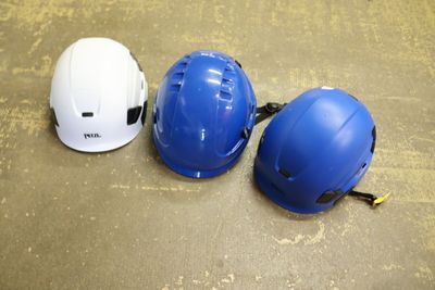 three hard hats are lined up on the floor next to each other