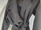 grey jacket with a tie on the front and a black shirt on a hanger
