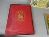a red book sitting on a table next to a yellow book