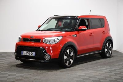 Une voiture rouge est garée sur un sol à damier dans une pièce.