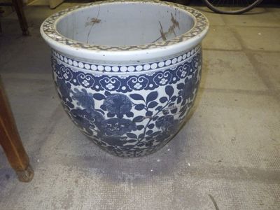 un grand vase bleu et blanc posé par terre