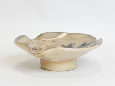 a small bowl with a bird on it on a white surface
