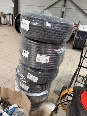 many rolls of wires stacked on top of each other in a warehouse