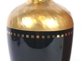 a black and gold vase sitting on a table