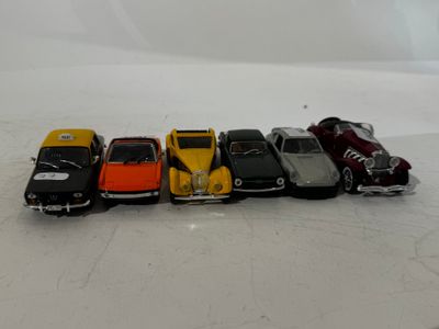 several toy cars are lined up in a row on a white surface