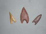 trois pointes de flèche de couleurs différentes posées sur une surface grise