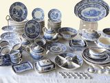 many blue and white plates and bowls on a table