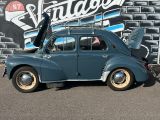 a blue car that is parked in front of a wall