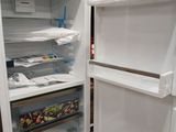 a white refrigerator with its door open in the kitchen