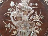a picture of a wooden table with a bird and flowers on it