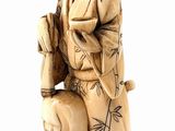 statue of a man in a kimono sitting on a stool