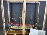 une maquette en bois d'un navire exposée dans une vitrine