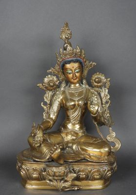 une statue en or représentant une personne assise sur une table