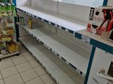 many empty shelves in the store with drinks on them