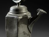 an antique silver teapot with a bird on top of it