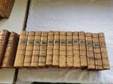 de nombreux vieux livres empilés les uns sur les autres sur un lit