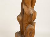 wooden sculpture of a woman sitting on a rock on a white background