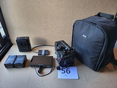 un appareil photo et d'autres appareils électroniques posés sur une table près d'une fenêtre