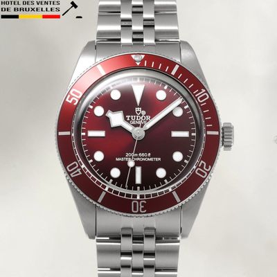 a picture of a watch with a red dial