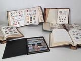 several open books sitting on top of a table with stamps on them