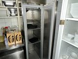 a refrigerator in the kitchen with dishes on the shelves