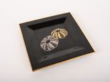 a black and gold plate with a snake on it