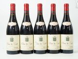 six bouteilles de vin sont alignées sur une table