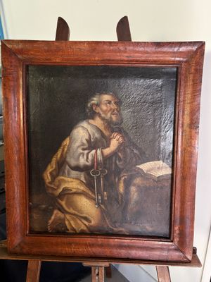 un vieux tableau représentant un homme tenant un livre posé sur un chevalet