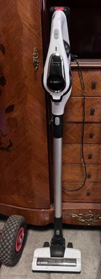 a vacuum that is sitting on the floor in front of a cabinet