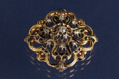 une image représentant une broche en or et diamants sur un fond bleu
