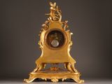 a gold clock sitting on top of a table