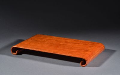 une image représentant un plateau en bois posé sur une table, sur fond gris