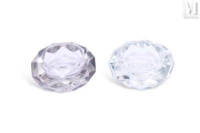 un gros plan sur deux boutons en verre transparent posés sur une surface blanche