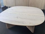 a wooden table with a wooden base in a room
