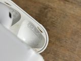 a person holding a pair of airpods in their hand