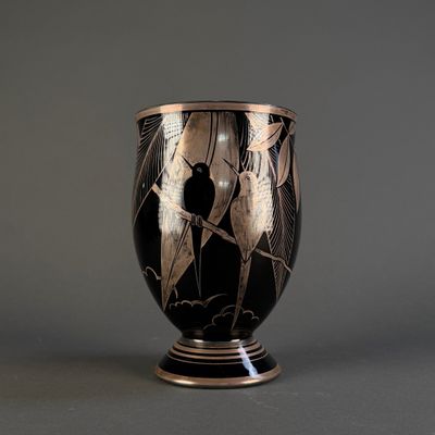 a vase with a black and gold design on it
