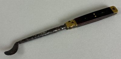 a close up of a knife on a white surface with a black handle