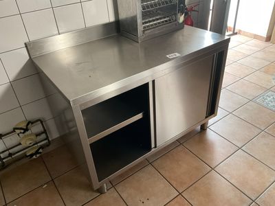 a stainless steel counter in a kitchen with tile flooring