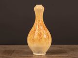 un vase orange et blanc posé sur une table en bois