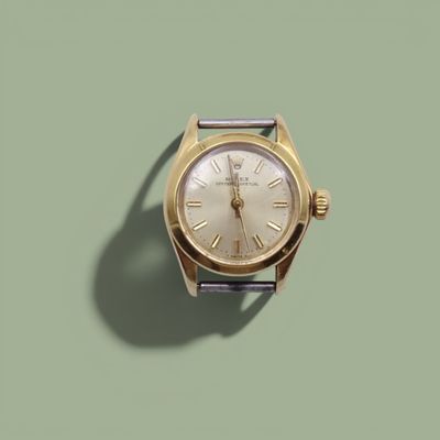une montre en or avec des chiffres romains sur fond vert